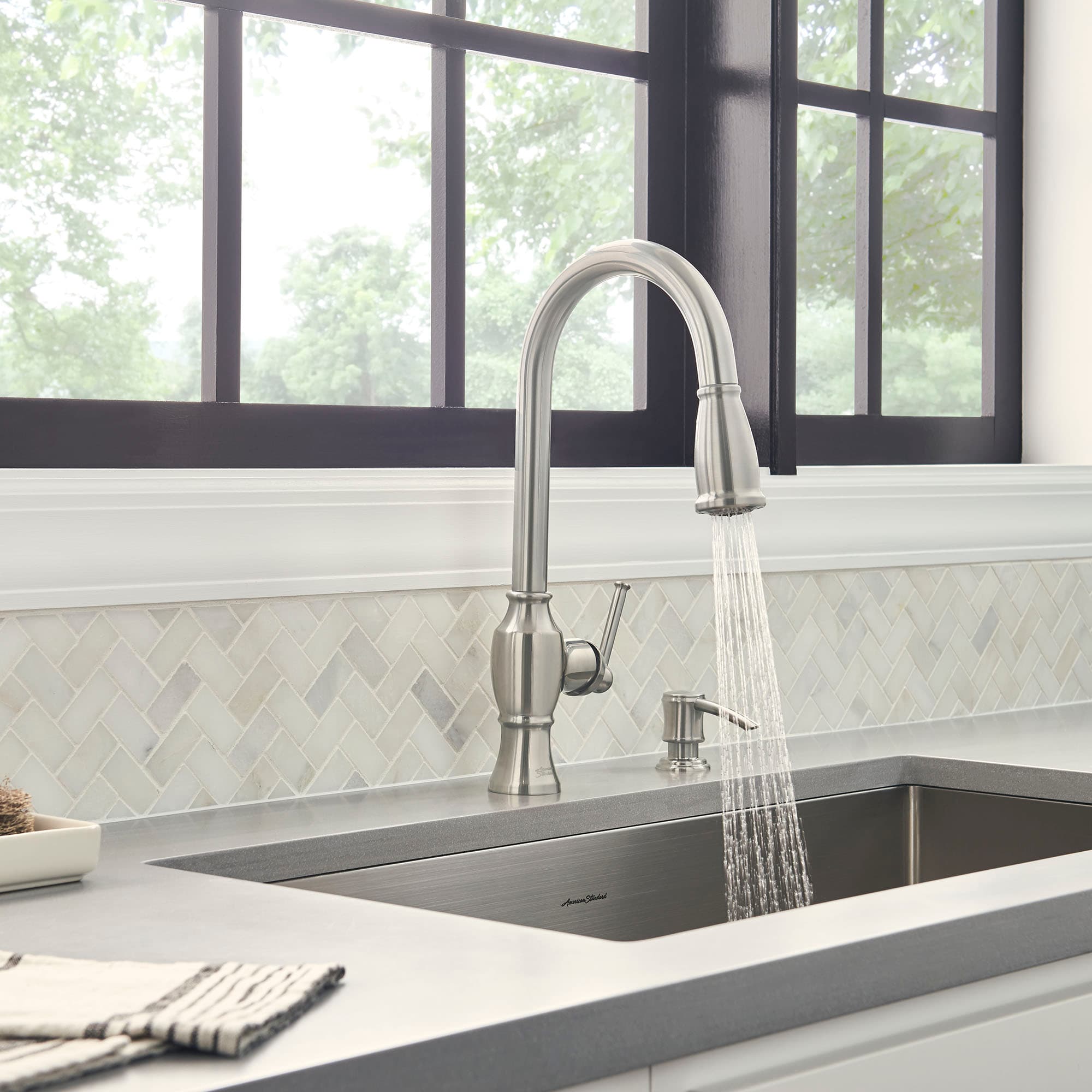 A newly installed kitchen faucet at a sink.
